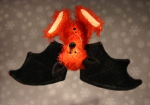 auf dem Kopf hängende rote Fledermaus aus Mohair mit schwarzen Flügeln