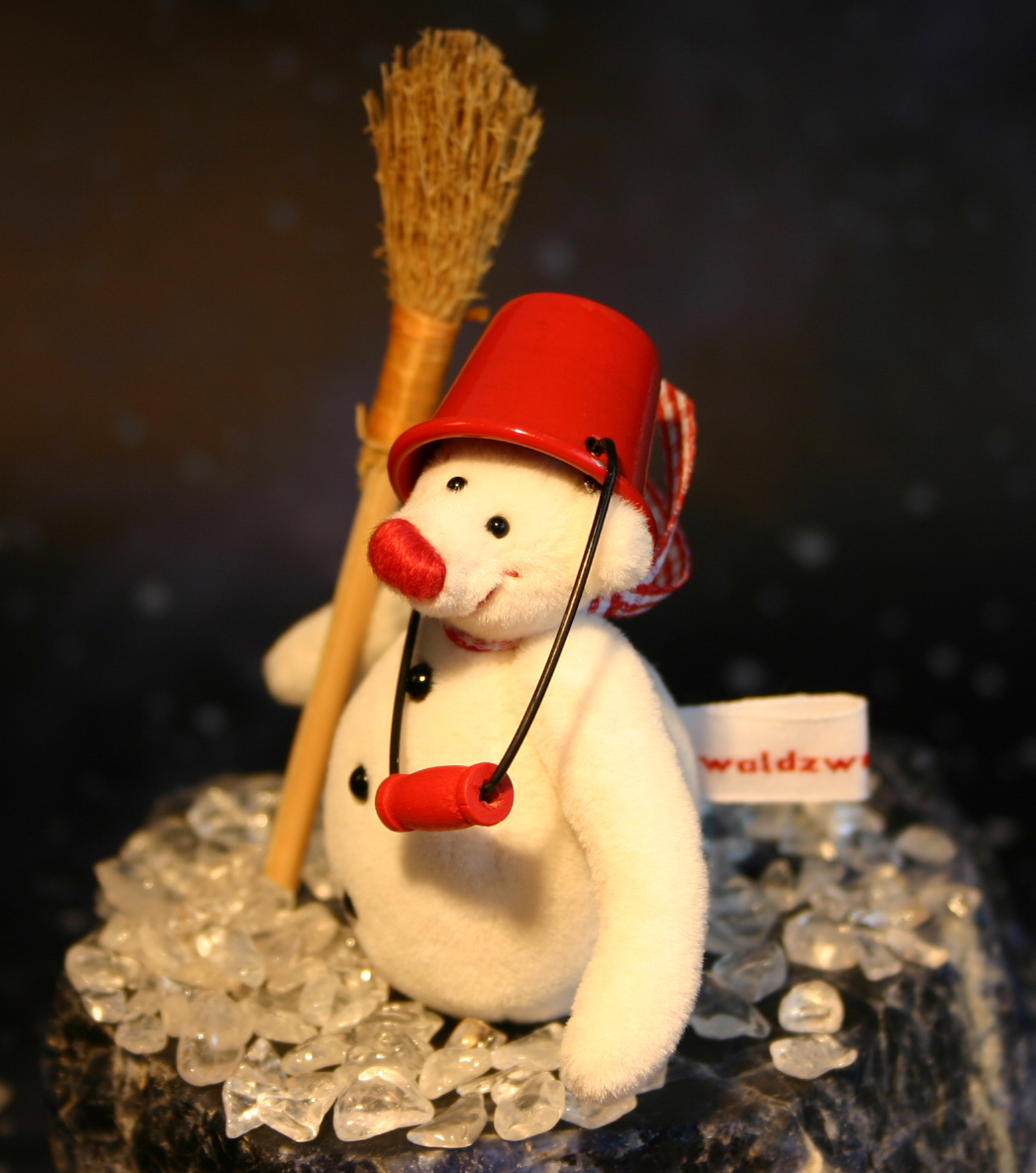 Waldzwerge Schneemann mit rotem Eimer als Hut und Besen mit schwarzem Hintergrund