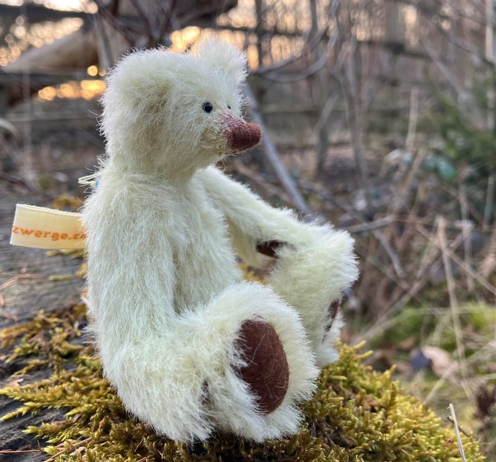 Profilbild kiwi grüner Waldzwerge Teddy mit brauner Nase und Fußsohlen sitzend auf Moos im Wald
