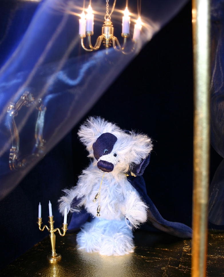 hellblauer Waldzwerge Teddy mit langem Mohair als Phantom der Oper in einem Theaterraum mit Kerzenständer und Kronleuchter