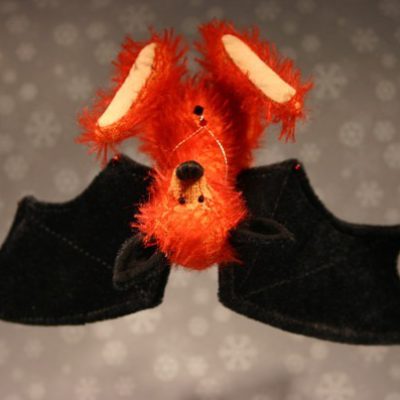 auf dem Kopf hängende rote Fledermaus aus Mohair mit schwarzen Flügeln