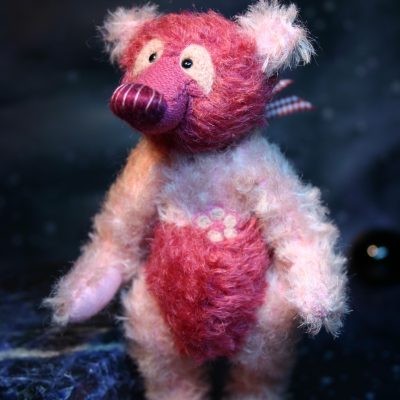 Waldzwerge Panda Teddy in rosa und dunkel pink stehend vor dunkel blauem Hintergrund